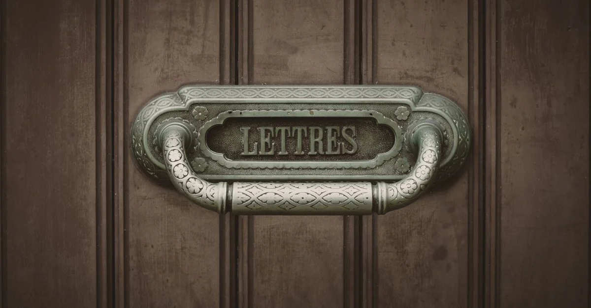Boîte aux lettres vintage ornée, étiquetée 'Lettres', devant une porte en bois rustique, évoquant le charme d'antan.