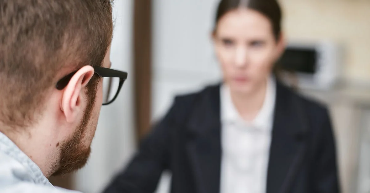 Des professionnels en affaires discutent dans un bureau moderne, mettant l'accent sur le travail d'équipe et la collaboration.