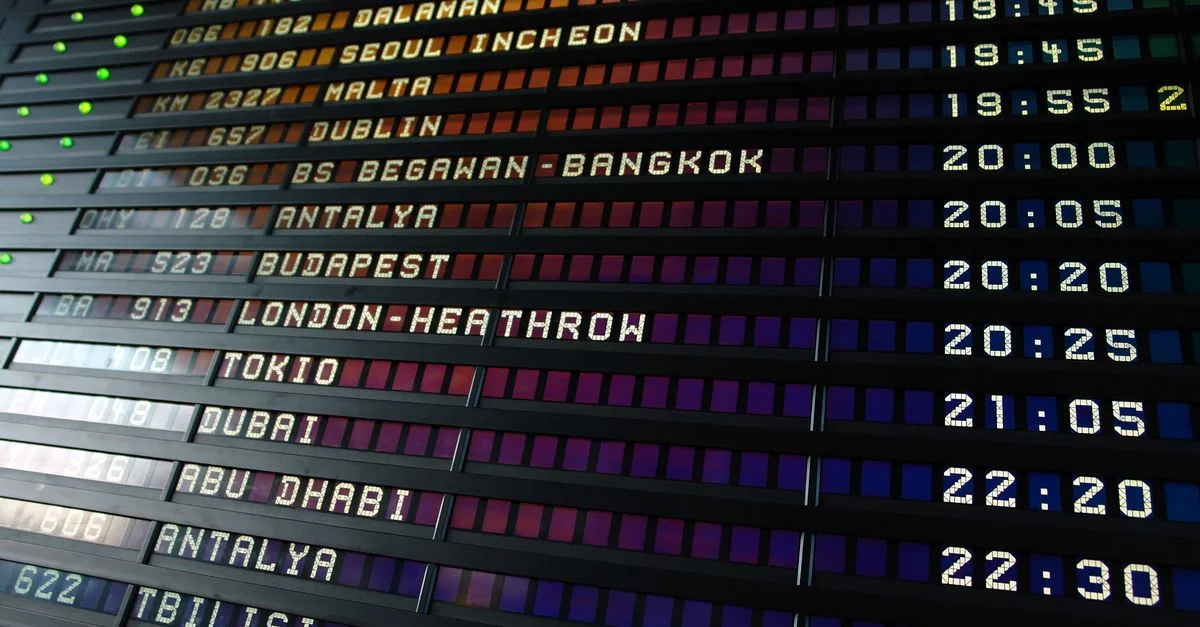 Panneau d'affichage rétro à rabat des départs d'aéroport indiquant les destinations et les horaires des vols internationaux.