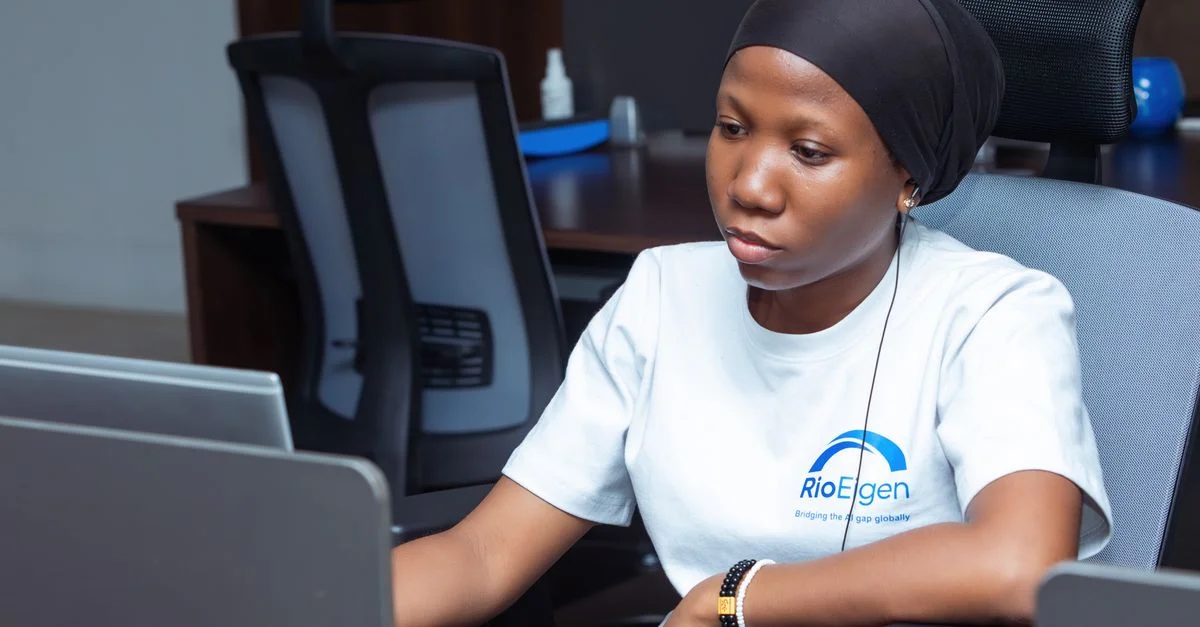 Une jeune femme professionnelle travaillant sur un ordinateur portable dans un environnement de bureau moderne.