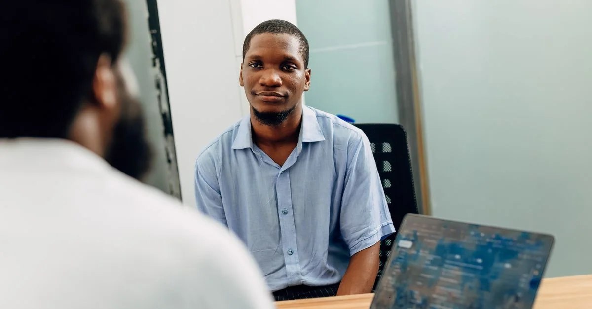 Une réunion d'affaires dans un bureau moderne à Lagos, au Nigéria, avec deux professionnels engagés dans une discussion.
