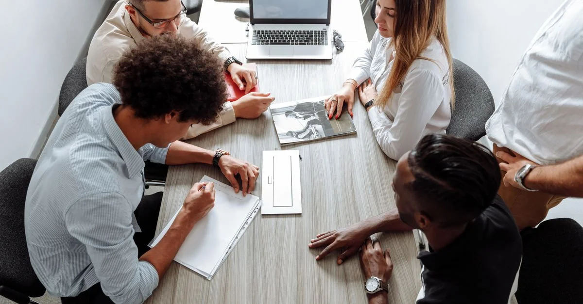 Groupe de professionnels divers collaborant dans un cadre de bureau moderne.