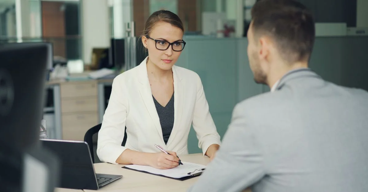 Deux professionnels lors d'une réunion d'affaires sérieuse dans un bureau moderne.