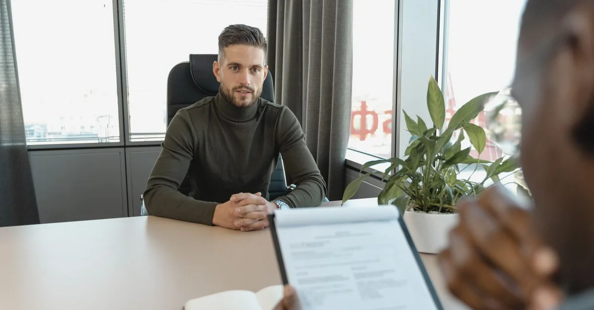 Homme professionnel en col roulé à son bureau durant un entretien.