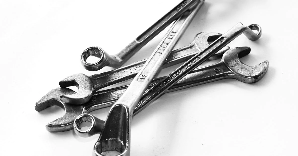 Une collection de clés en acier exposées sur un fond blanc, parfaites pour les trousses à outils.